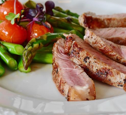 Medium-rare meat slices with asparagus and baby tomatoes